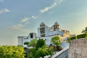 Weißer Palast über grünen Bäumen unter blauem Himmel in Indien Weißer Palast über grünen Bäumen unter blauem Himmel in Indien