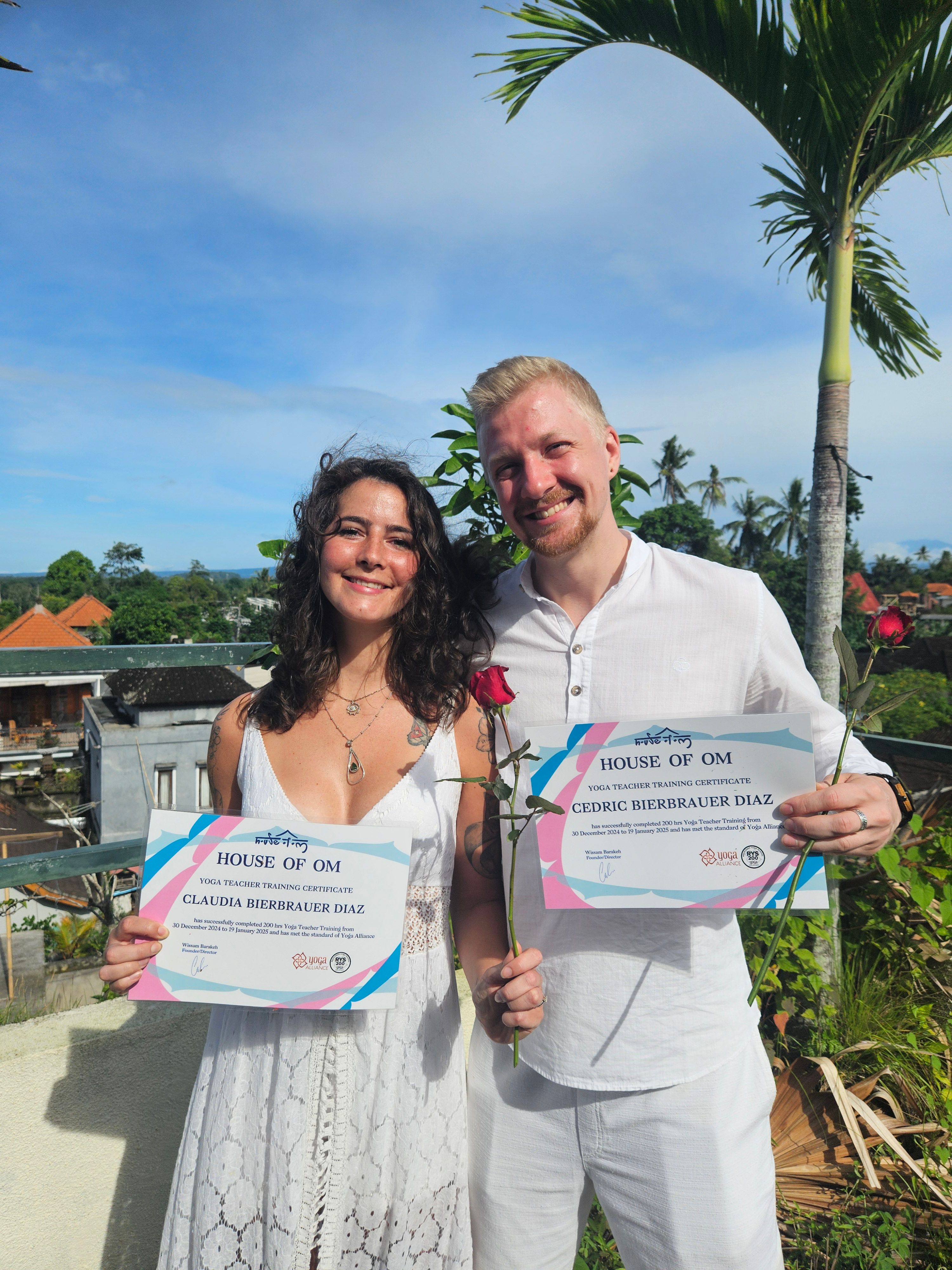 Cedric und Claudia Bierbrauer Diaz halten lächelnd ihr Yogalehrer-Zertifikat über 200 Stunden Yoga Teacher Training.