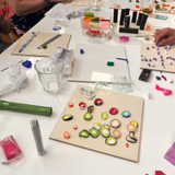tafel met fimoklei tegels en hand