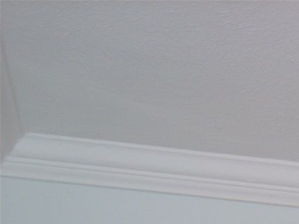 Wooden curtain pole fitted offset over a front door.