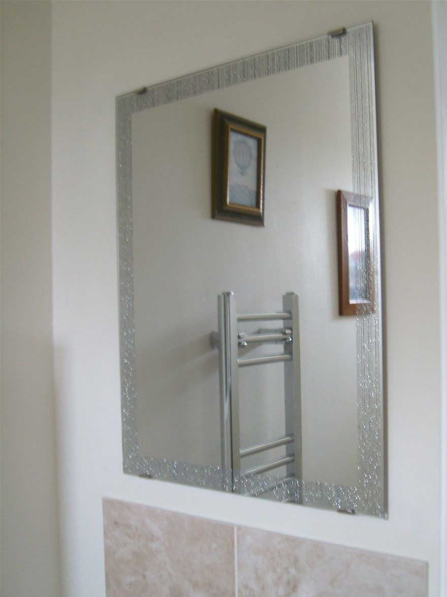 Frameless mirror fitted above a cloakroom basin