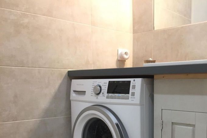 Salle de bain équipée d'un lave linge.