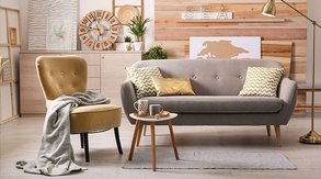 Omklädda möbler i ett vardagsrum, en fåtölj i gul sammet och en soffa i beige möbeltyg. Omklädda möbler i ett vardagsrum, en fåtölj i gul sammet och en soffa i beige möbeltyg.