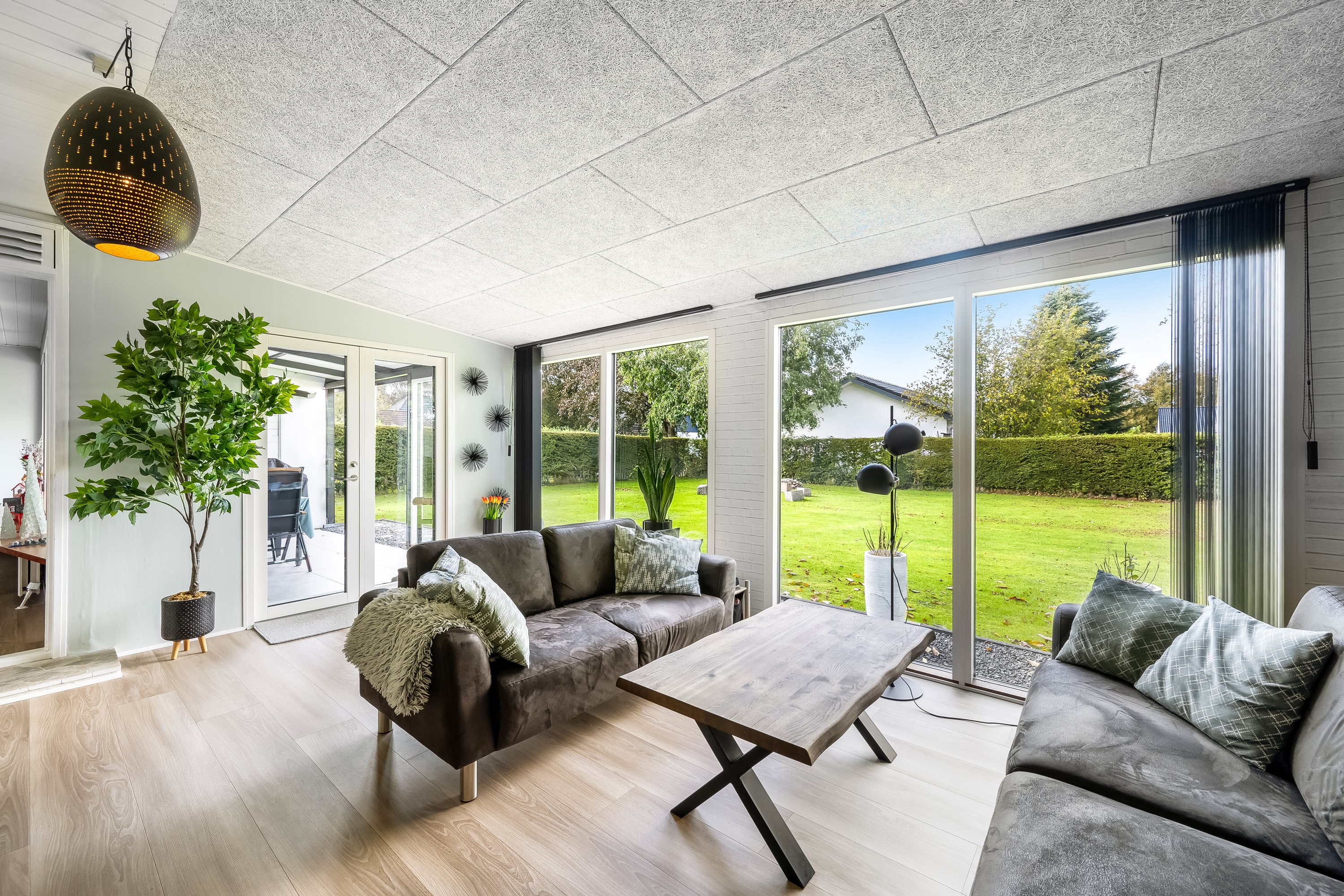 Stue før styling med grønne puder og tæpper på sofaerne