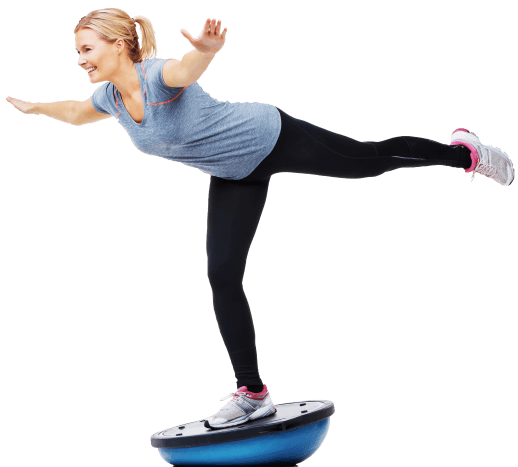 Smilende kvinde balancerer på en original BOSU bold