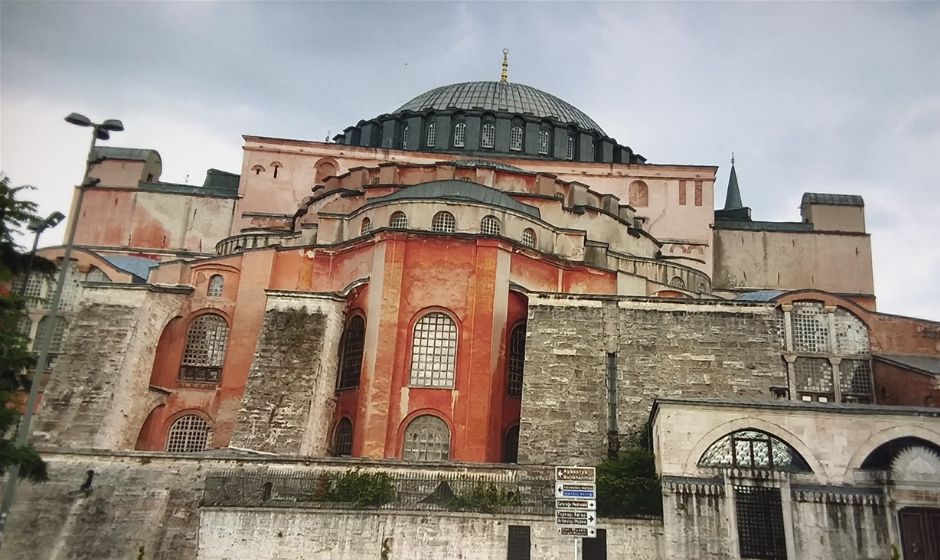 Out side of the Hagia Sophia in Istanbul on a rainy day. It was only a light sprinkle by the time we got there so we had no problem with the moisture. Hagia Sophia is magnificent. It is on the opposite end of a well maintained park that used to be a hippodrome in ancient times from where the Blue Mosque is located. We were able to walk here in only 10 minutes time, up a narrow cobblestone road that lead us up a slight incline. Our hotel (Basileus) was about half way between the former hippodrome and the Sea of Marmara. The neighborhood is the Sultanahmet area of Istanbul which is the southeast portion of the European side of Istanbul. Cross the Bosporus Strait and you will be on the Asian side of Istanbul. We loved staying in the Basileus Hotel because it was really cozy with a front desk which was just a desk where we sat across from the proprietor who checked us in and conversed with us in a friendly, familiar fashion. The hotel is at Küçük Ayasofya Mehmet Paşa 1.  Oh, and Ayasofya is the real way to spell Hagia Sofia. We paid less than $50 a night for a very nice hotel stay. The breakfast buffet was one of the best I have ever seen and we even had complimentary cookies and breads that were home made. They were on a table in the hallway between the living room like lobby and the rooms. There was also complimentary tea in a large dispensar on the table. The former hippodrome is now a very well maintained park or square called the Sultanahmet Square and the Obelisk of Theodosius stands there. Sultan Ahmad Maydan Fountain is a little further up the walkways and then the Ayasofya Müzesi (Hagia Sophia museum) will be the next destination you arrive to. There are many other sites around the square and I recommend that all visitors take a whole day just in this lovely neighborhood. Just be careful not to be lured into a carpet shop to drink apple tea and look at carpets because the sales pitches may come next. Actually, the sales pitches will come so enter only if you really do want to buy a carpet or rug.