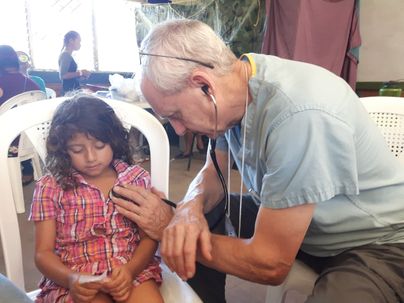 Dr Doug listens to a young patient's heart