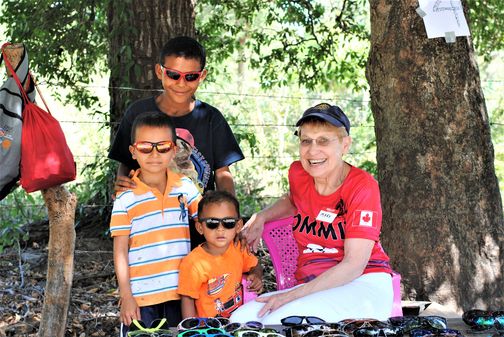 Mary giving out sunglasses donated by the Lion's Recycle for Sight