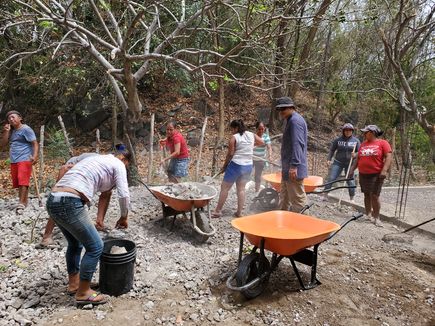 Levelling the ground beside the community centre and medical building