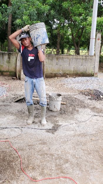 Jamil carrying one of the many pails of mortar 