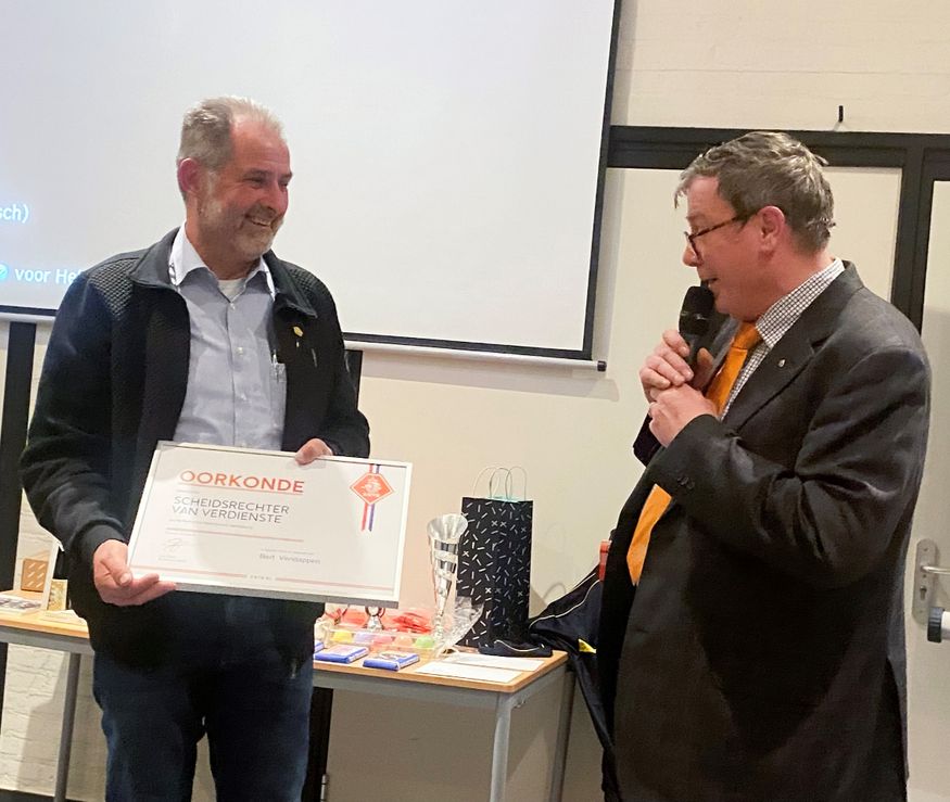 Bert wordt door KNVB-afgevaardigde Jan Heijnen benoemd tot Scheidsrechter van Verdienste en neemt de oorkonde en bijbehorende speld in goud in ontvangst. 