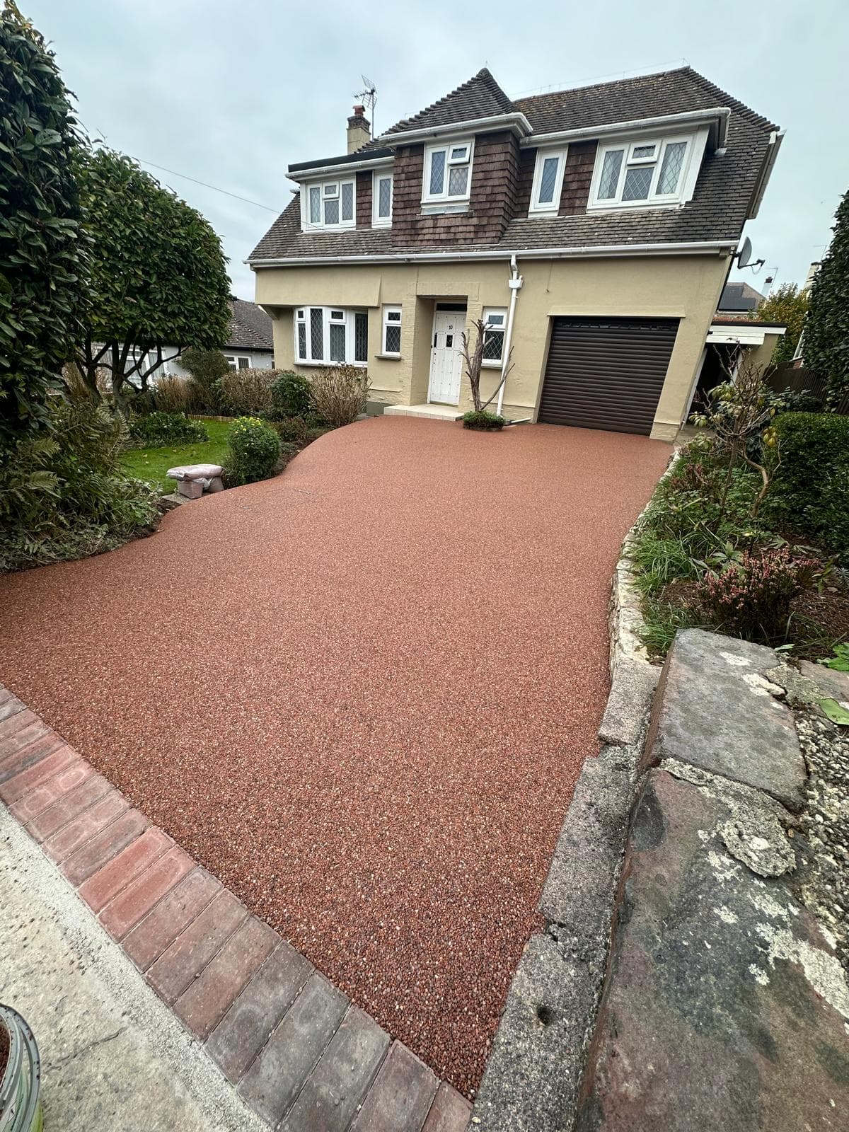 Resin‑bound driveway installation in Brixham, Devon. Autumn red colour combination.