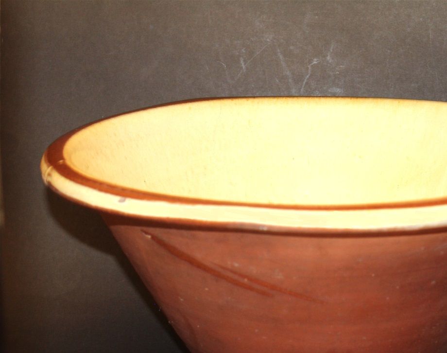 Bol gigantesque attribué à la Prince Edward Pottery Co, 1880-1898. Le Musée de l'Ile du Prince-Edouard en illustre un identique de sa collection. Engobe crème jaunâtre à l'intérieur, avec une bande brune sur le pourtour, sans glaçure à l'extérieur.