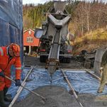 Bilete av mann som legg ut betong frå hydraulisk renne