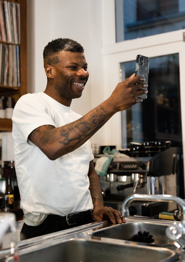 Man with tattoos smiling taking picture with phone Man with tattoos smiling taking picture with phone