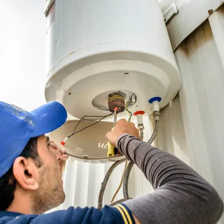  En professionel elektriker reparerer en vandvarmer på taget.