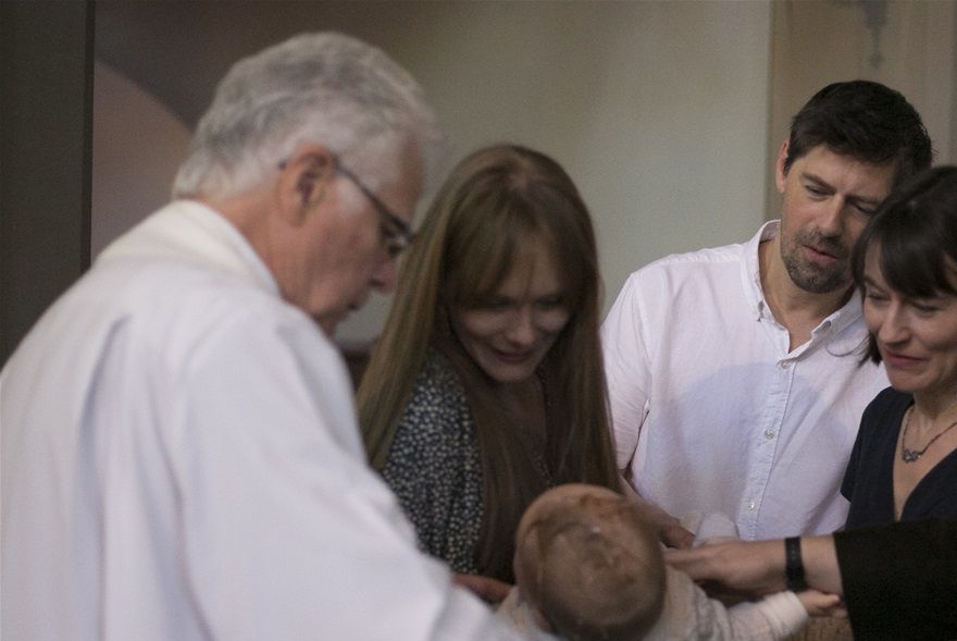 Father Martin baptises Ethan while godparents Ben and Nina watch with his proud mum and dad...