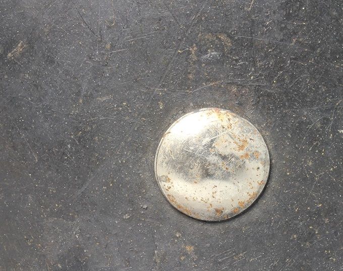 Steel rivet. Note all the paint has chipped of. Rust spots.