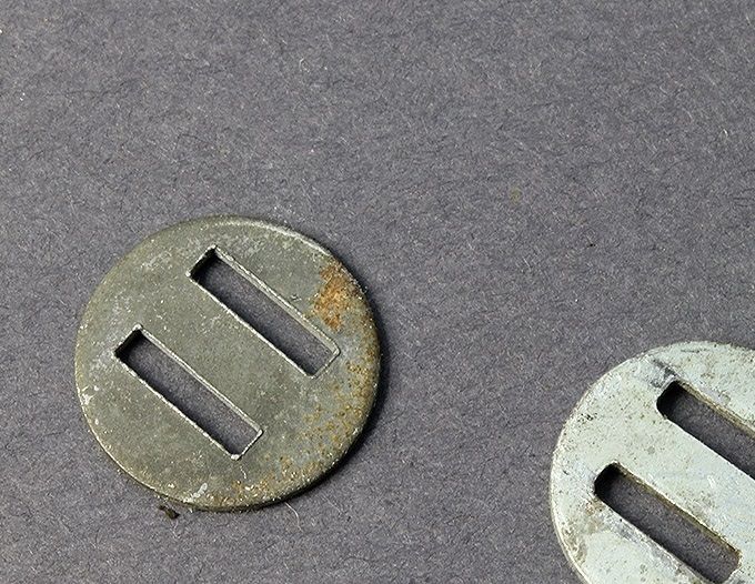 2 slotted washers. To the left a zinc coated steel washer, to the right an aluminum washer.