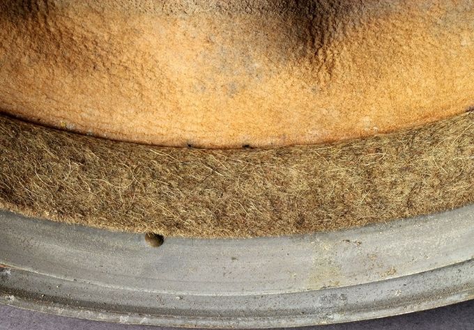 The wool supporting strip. This strip is placed between the leather and the metal band to improve comfort and to avoid rubbing of the fragile leather against metal. The wool strip has either a grey or grey-green color.