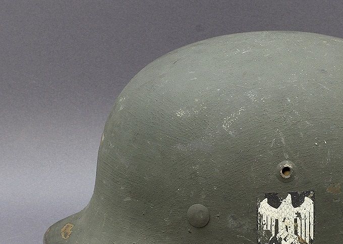 An M35 ET64 classical reissue with light grey sand-textured paint. While the paint has a rough sand texture, it is not regarded as a sand camouflage helmet. Notice the reissue-type Heer decal that has partially flaked off due to the rough surface. This type of reissue is common in Norway. 
