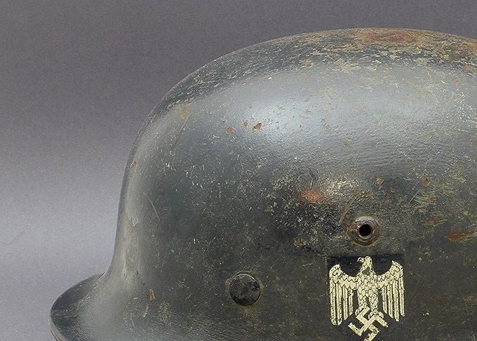 M35 ET66 repainted in dark blue. Most helmets in this color are Luftwaffe however this example is Heer. The factory applied decal has been painted around.