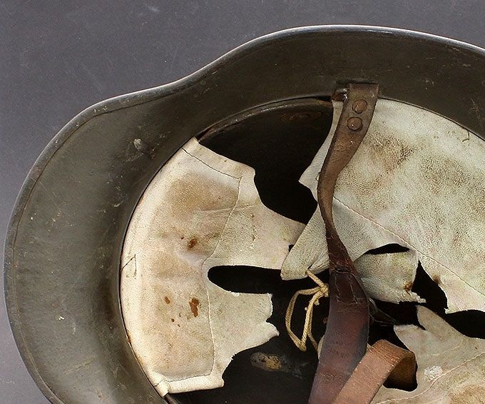 The liner of the M18 above. Notice the three liner pads and the broken WWI carbine-clip chinstrap, which is dry and stiff from age.