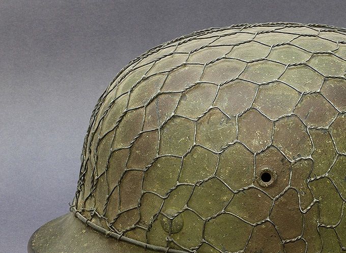 M40 ET64 camouflage helmet. Painted in green and red-brown and has a another construction of half-basket chickenwire (another Norwegian collection).