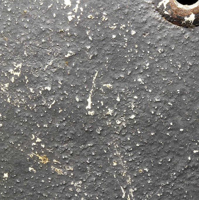 The paint structure of the M35 helmet above. Notice the small particles in the smooth dark blue paint. White paint shows where the particles/texture are worn off.