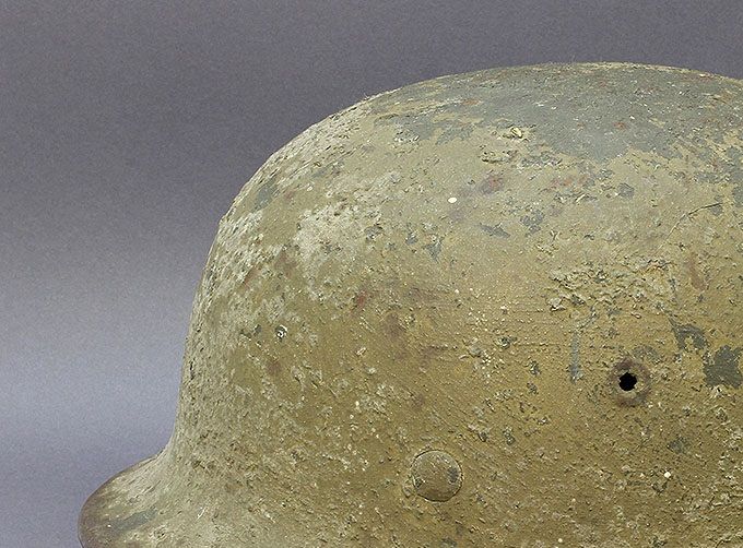 M40 ET66 multi-layer camo. The helmet was first brushed/sprayed with dark gray sand/woodchip paint, followed by a tan/olive green finish with woodchips.