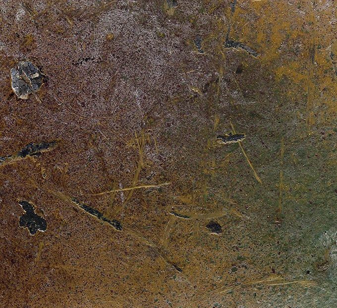 Close-up picture of the surface. Red-brown and green paint on top of the yellow mustard base. Notice the thin layer of whitewash over the paint.