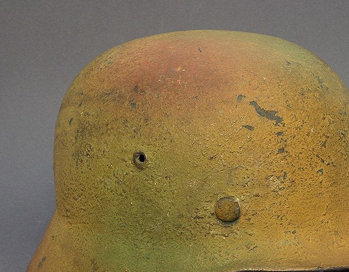 M35 ET64. Sprayed mustard yellow with a green and red-brown on top. The colors blend to each other and the paint contains sawdust and woodchips.