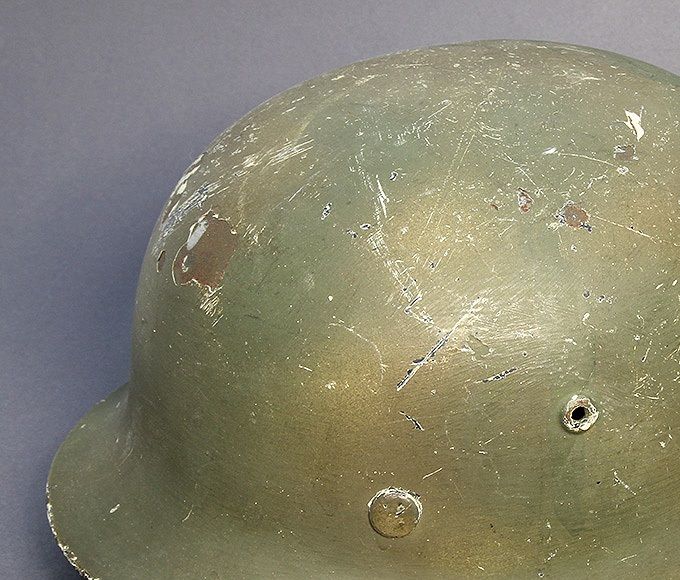 M40 ET66 hand-brushed green paint with sprayed tan paint in patterns. Underneath the camouflage paint is a layer of white winter paint.