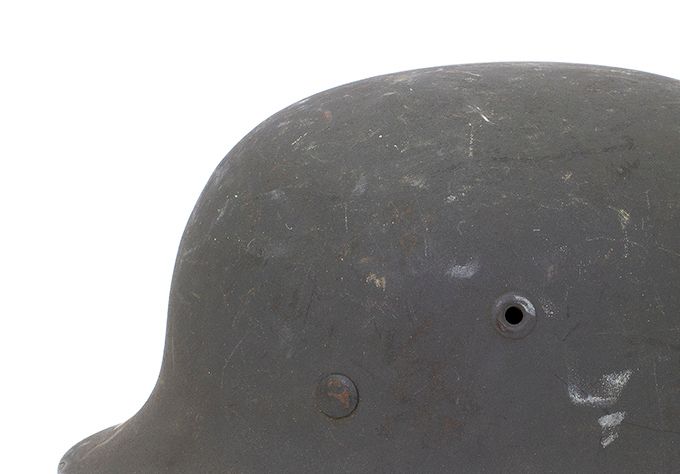 The M42 was produced from 1942 until the end of the war. Production was simplified due to increasing demands for more helmets and quicker supply to the various fronts. The pressed vent hole was retained but the rolled rim was abandoned in favor of a sharp-edged flared rim to simplify the manufacturing process. The rivets used are the same as the M40, namely zinc-coated steel rivets. The insignia on the left side was discontinued from mid-1943 onward.