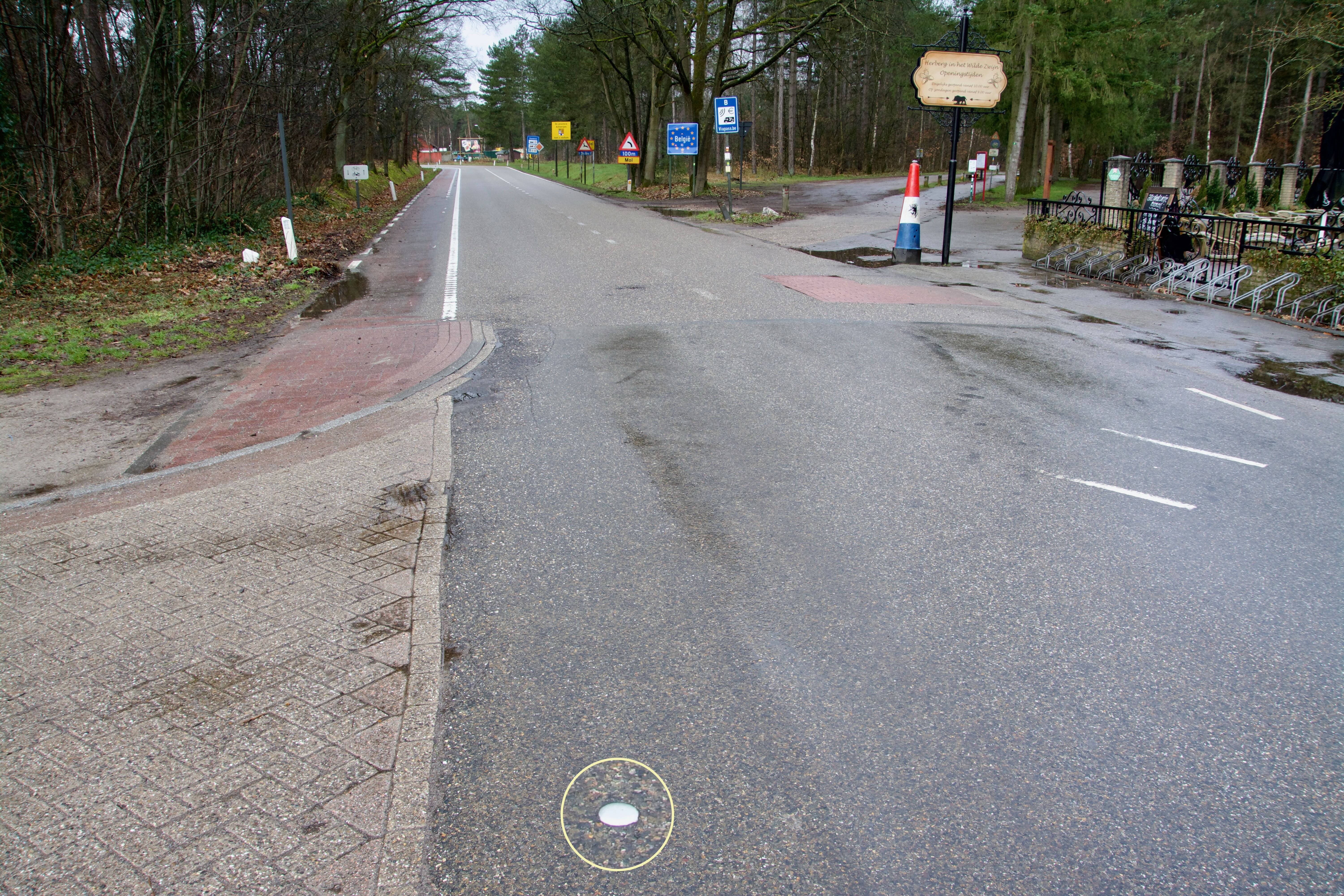 Aluminium dop in wegdek markeert grenspunt 144 bij grenspaal 197 tussen Witrijt en Postel