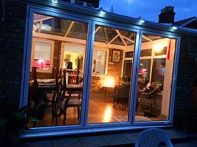 Smarts Aluminium 3-panel bifold door. Conservatory build and installed by Harrow Windows Ltd