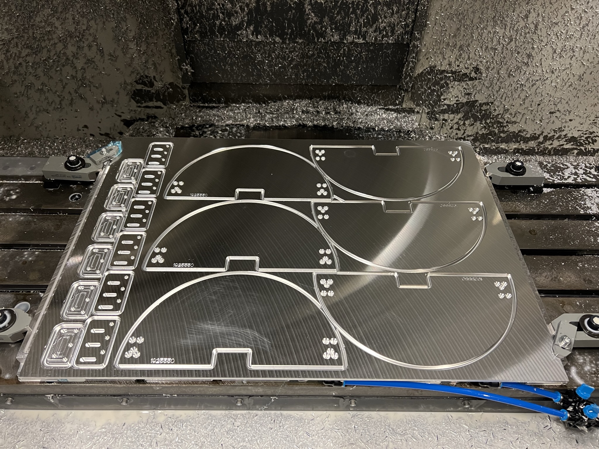 CNC-machined precision plates arranged on a machining table.