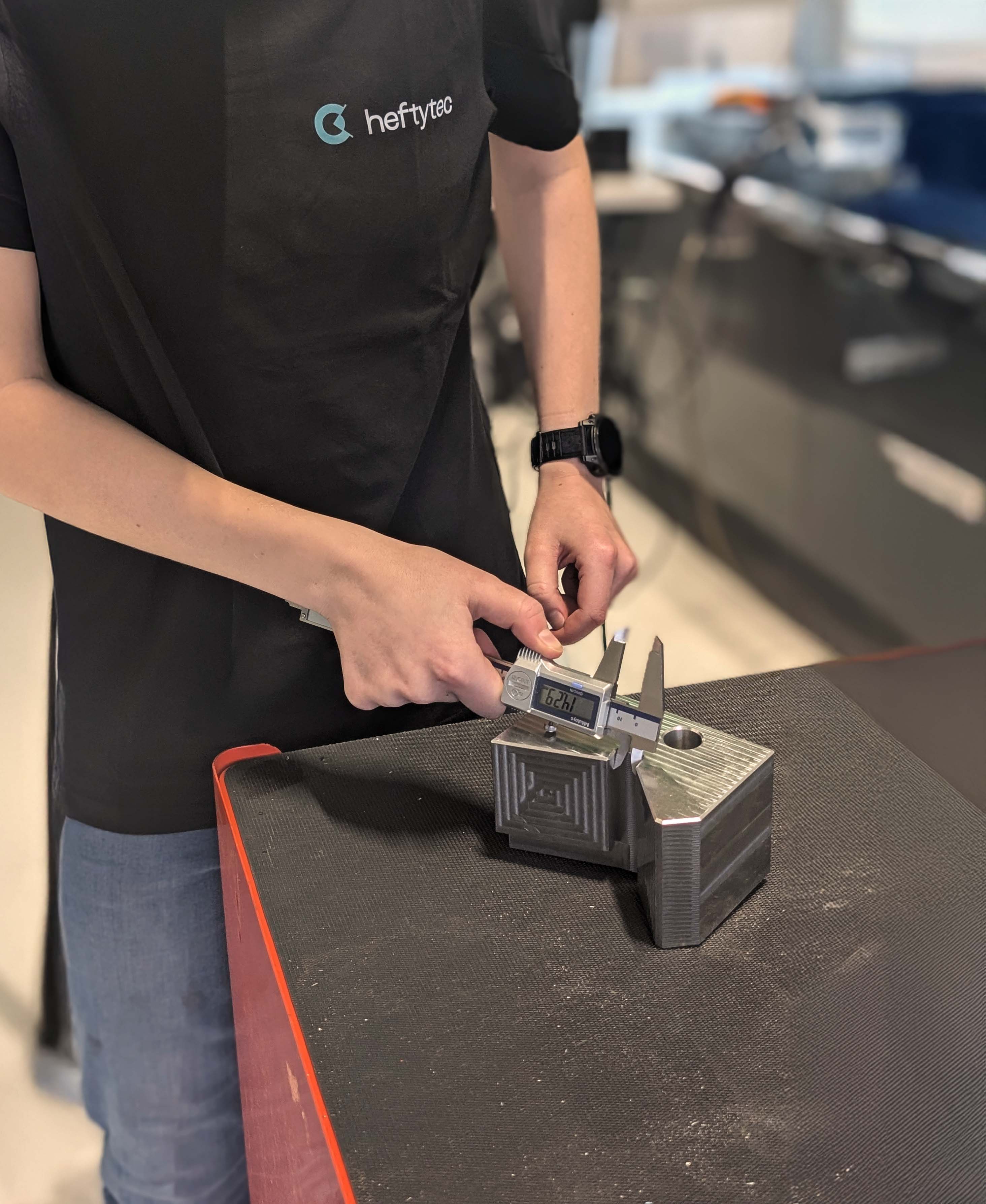 Precision component being measured with digital calipers.