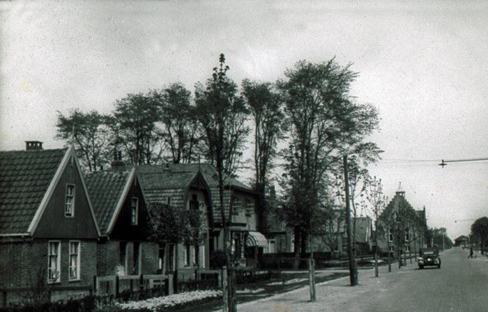 Foto uit 1947. Een stukje Middenweg in het Centrum vlak na de oorlog.
De twee huisjes links zijn gesloopt voor de aanleg van de Vondellaan.
Het vierde huis is de slagerij van slager N. Stam tot 1946, toen Rietbergen en Zn. Tot april 1962, daarna trok slager Schilder erin en vanaf 1986 was het de apotheek Heerhugowaard. In 2017 was er  een winkel in gehoorhulpmiddelen in gevestigd. In de verte ziet u het oude gemeentehuis bijna op de Middenweg staan. Nog verder rechts de torenspits van de oude Dionysiuskerk.