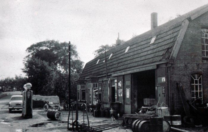 De foto van het bedrijf van Smederij Rentenaar, op het eind van de Kerkweg, richting Dijkweg.  Aris Rentenaar, smidsknecht bij Dirk Kruijt die in 1847 de smederij bouwde. Aris Rentenaar nam in 1912 het bedrijf over voor f2600,- Later heeft zijn zoon, Jaap Rentenaar het bedrijf overgenomen. Jaap (in de buurt bekend als vader Jaap) is uiteindelijk in de Zicht in Heerhugowaard Noord gaan wonen. Daar heeft hij nog menigeen met zijn auto naar het ziekenhuis gebracht.  De zoon van Jaap, Aris heeft in de smederij een installatiebedrijf gehad. In de eerste jaren samen met zijn broer Auke, later alleen. Het gedeelte wat smederij was, is in 2015 verbouwd tot woonhuis. Daar woont nu een dochter van Aris. De travalje (waar paarden in vaststonden als ze beslagen moesten worden) staat nog in de hal van het huis op de plek waar hij ook in de smederij stond. De smederij zoals op de foto is uit de periode 1924-1927. De smederij die 