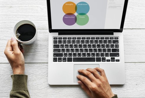 Man sitter vid laptop med en kaffekopp Man sitter vid laptop med en kaffekopp