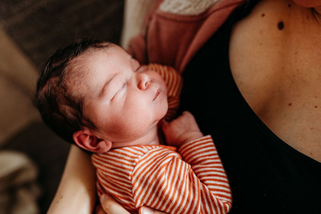 Neugeborenes schläft auf Mamas Arm - Wochenbett Fotos Landshut München
