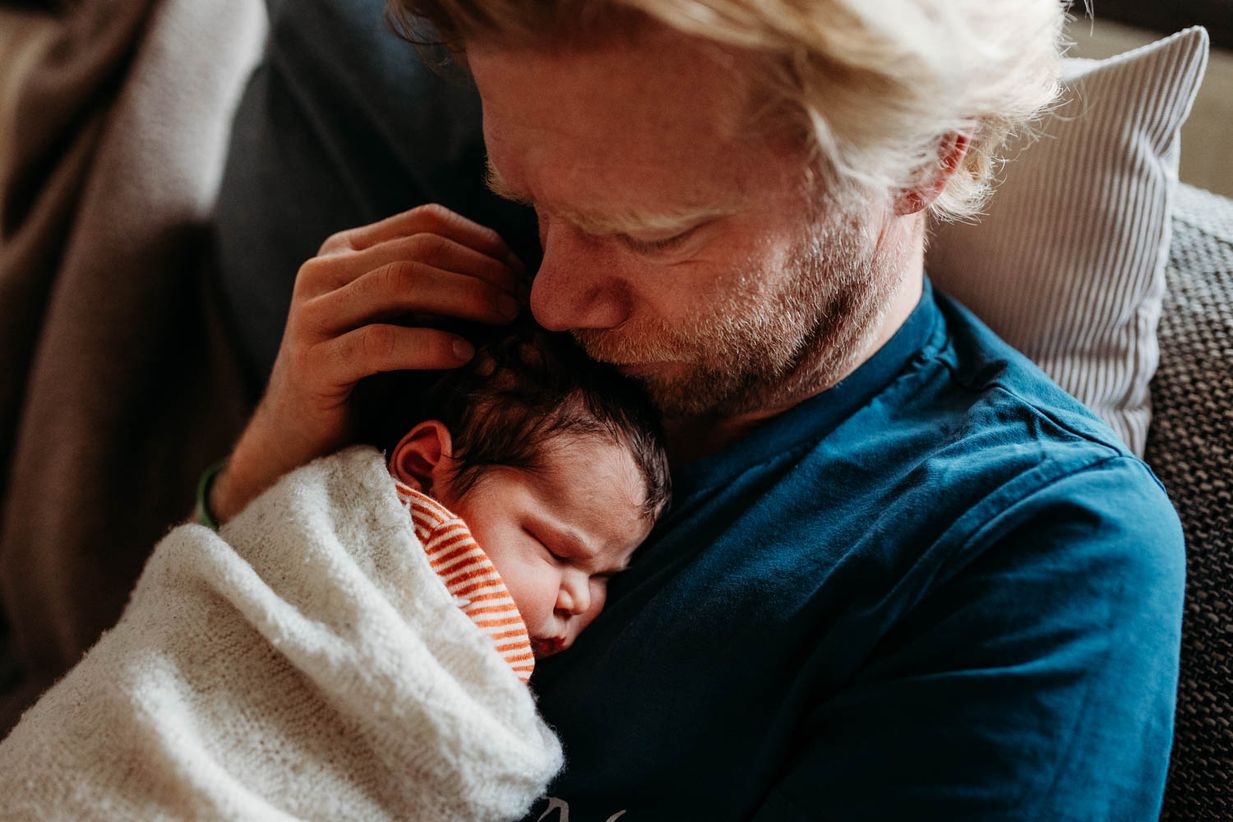 Papa kuschelt zärtlich mit dem Baby - Newborn Fotos Landshut München