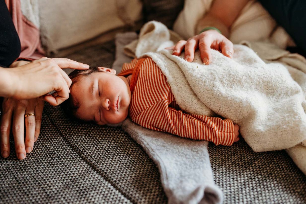 Baby wird zärtliich gestreichelt - authentische Newborn Fotos Landshut