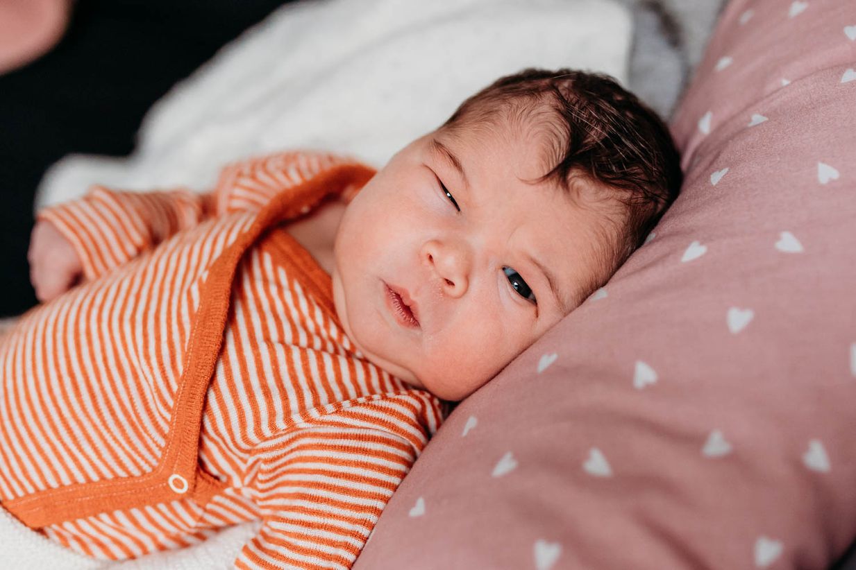 Neugeborenes blinzelt ins Licht - Baby Fotograf Landshut und München
