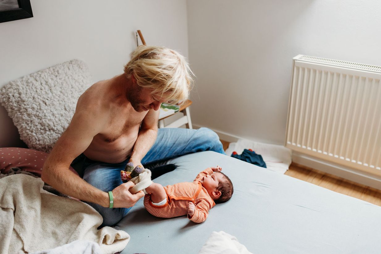 Vater wickelt Baby - natürliches Babyshooting Landshut und München