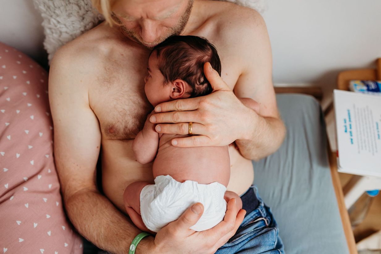 Papa kuschelt skin-to-skin mit Baby - Babyfotografie Landshut -München