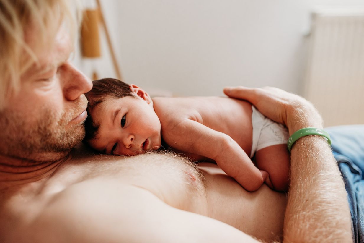 Baby liegt auf Brust des Vaters - entspannte Baby Fotos München