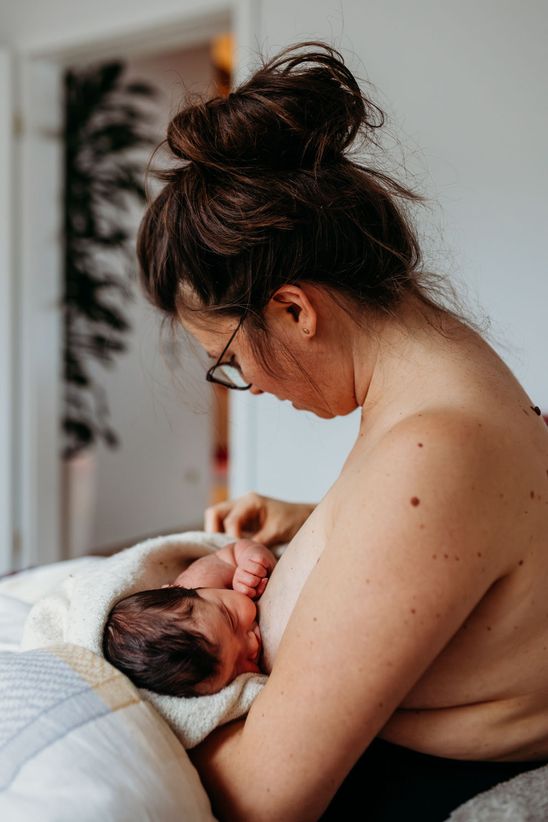 Baby wird von Mama gestillt - dokumentarische Newborn Fotos München