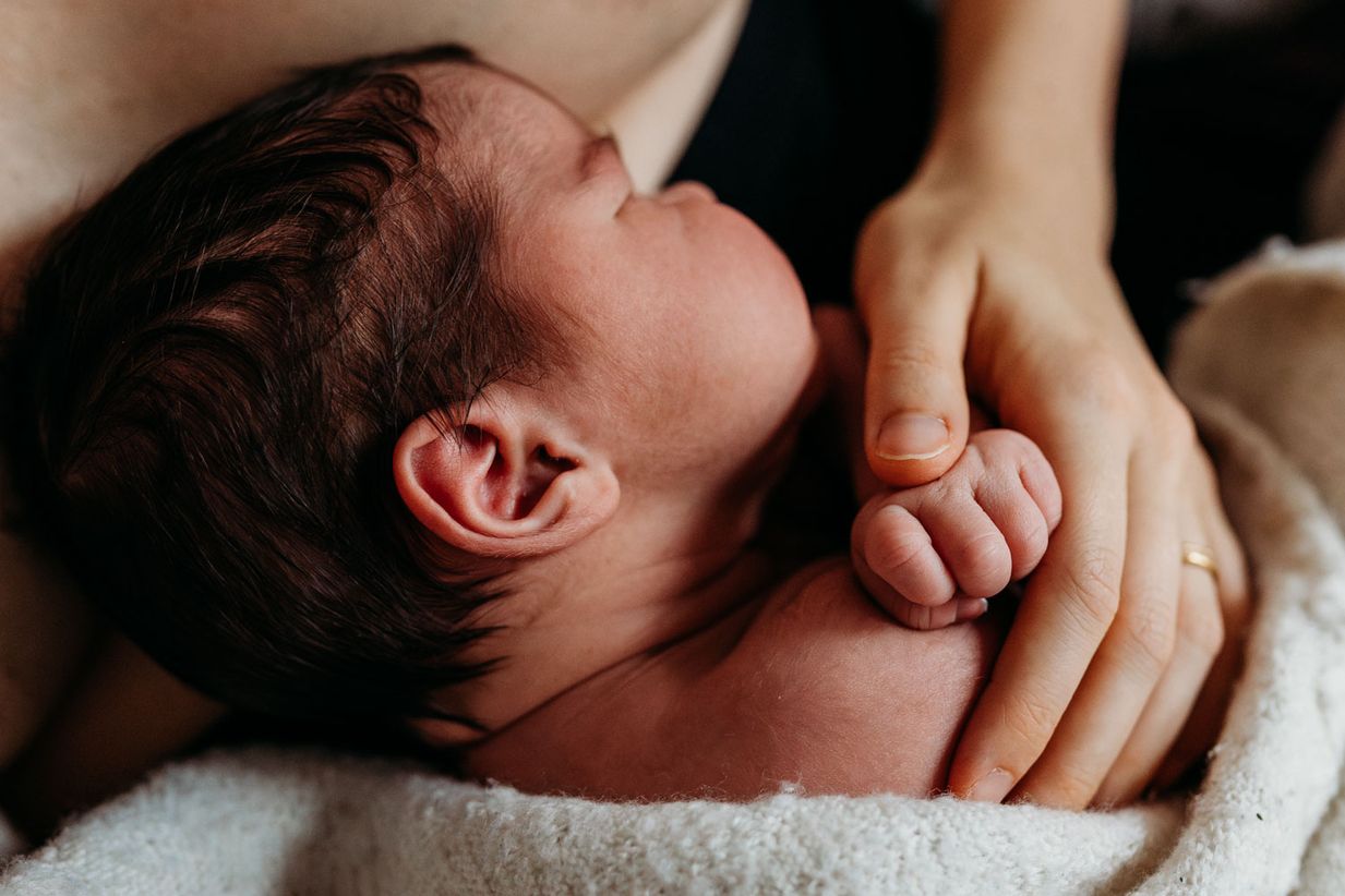 Mama streichelt Neugeborenes - Detailfoto Babyshooting München